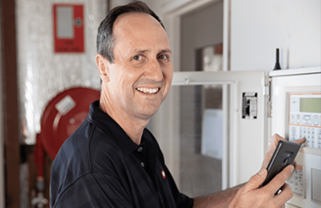 man checking fire alarm panel with FireMate software