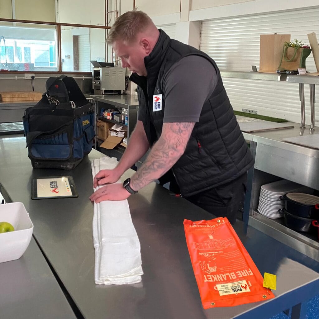 Technician servicing kitchen fire blanket