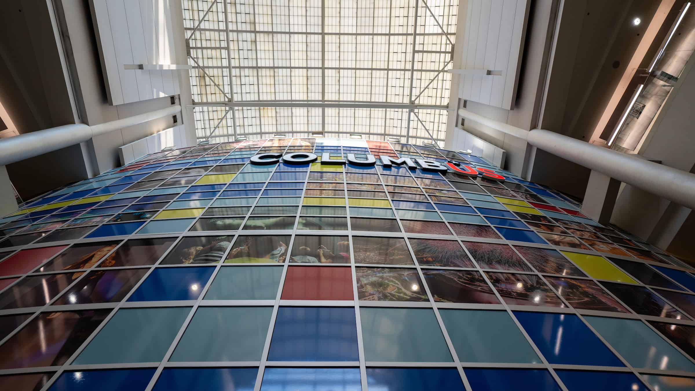 An image of a colorful Columbus mural with a glass at John Glenn International, Columbus Airports.