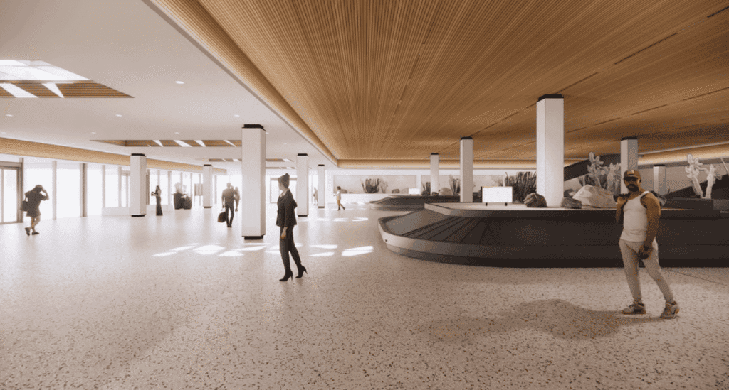 A modern airport baggage claim with high ceilings, wooden accents, two dark baggage carousels, and several people, including a man in a white tank top in the foreground.