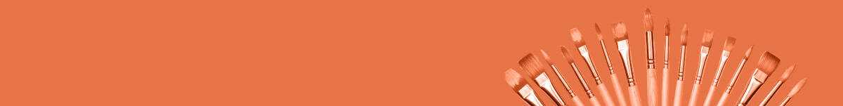 Multiple paintbrushes of various sizes and shapes fanned out on a solid orange background.