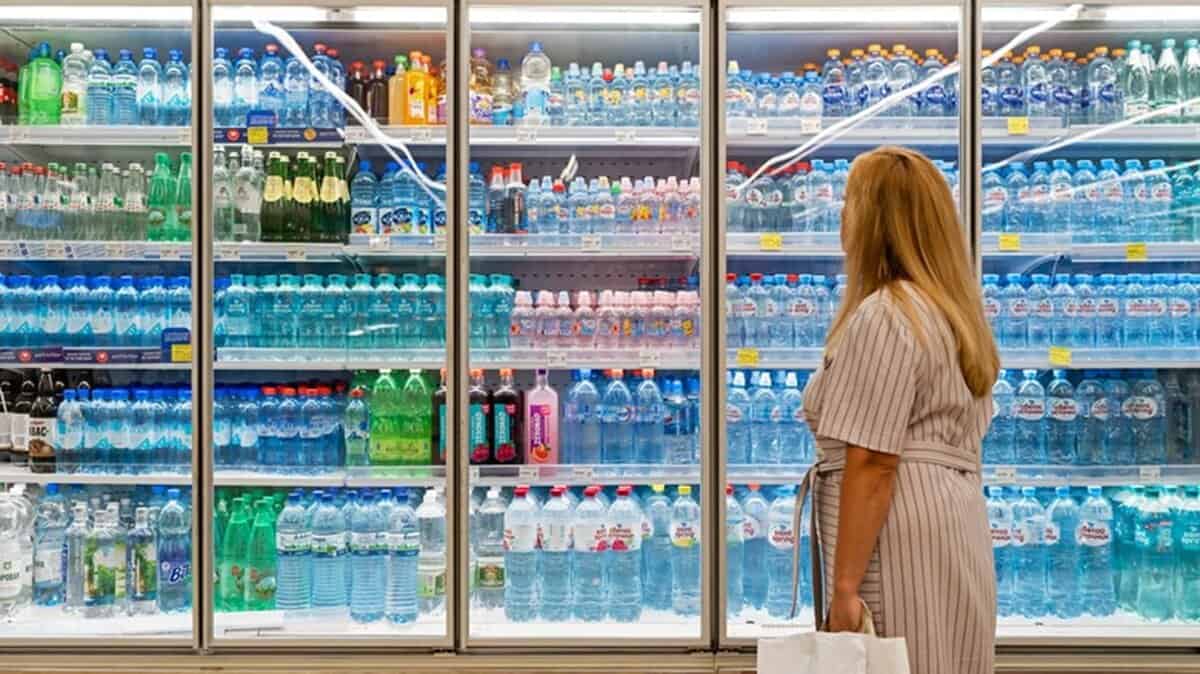 Bottled water and beverages in supermarket fridge for food safety and hygiene.
