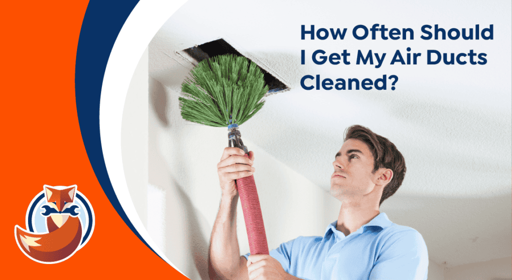 A man uses a large brush to clean an air duct in the ceiling. Text reads, “How Often Should I Get My Air Ducts Cleaned?” A fox logo appears in the corner, highlighting the importance of regular air duct maintenance.