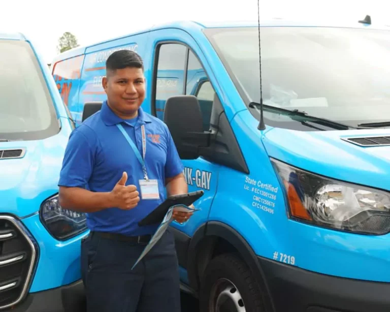 A man in a blue uniform gives a thumbs-up while standing in front of a blue service van, holding a clipboard. Wondering "Why Choose Us?" His confident stance and readiness to help answer that question instantly.