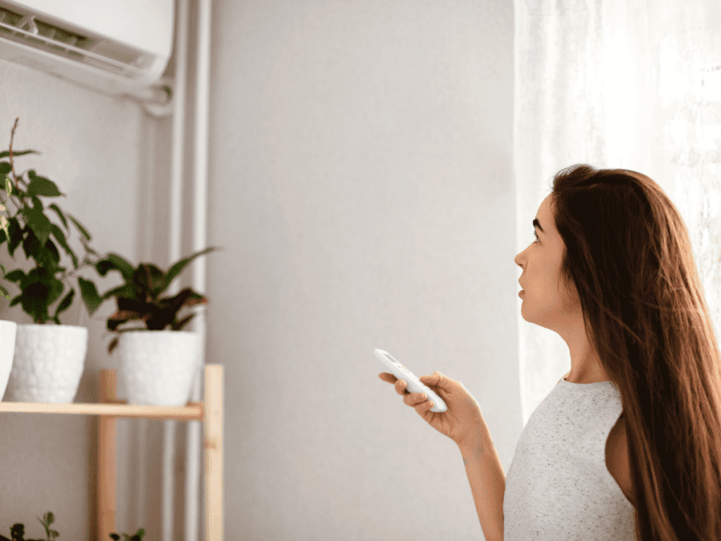 woman controlling mini split air conditioning unit in her home