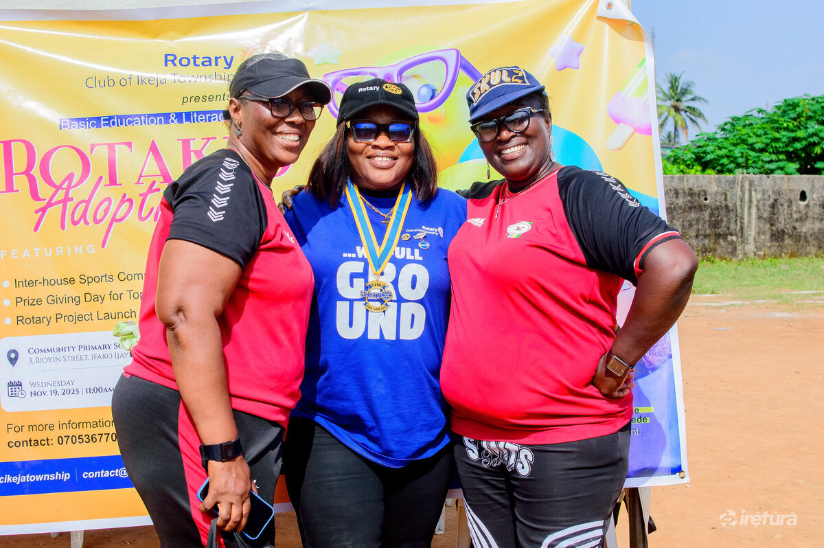 Smiling women in sports jerseys at a Rotary Club community event promoting literacy and education literacy on an outdoor field in Ikjeja Township.