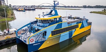 FRISIA E-1 electric ferry docked at harbour, eco-friendly maritime transport, sustainable ferry boat in service, innovative electric vessel, environmental shipping technology, green transportation.