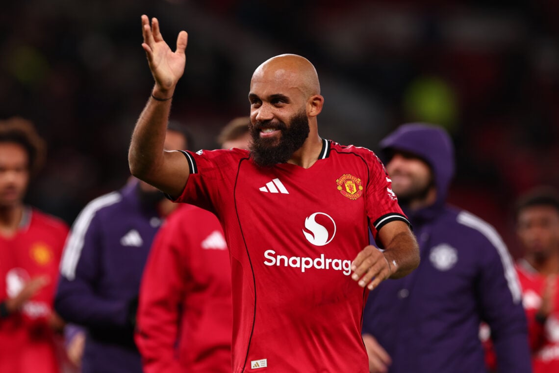 Manchester United football player celebrating victory on the field in a red jersey with the Snapchat logo, surrounded by teammates, during a live sports event.