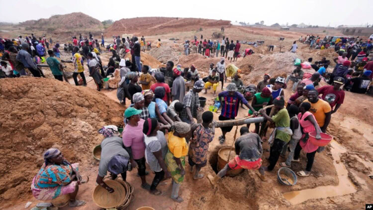 Large group of people working together on construction or excavation project in a rural area, showcasing community effort and labour.