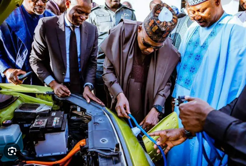 High-ranking officials and engineers inspecting an electric vehicle engine, symbolising innovation and clean energy initiatives in Nigeria.