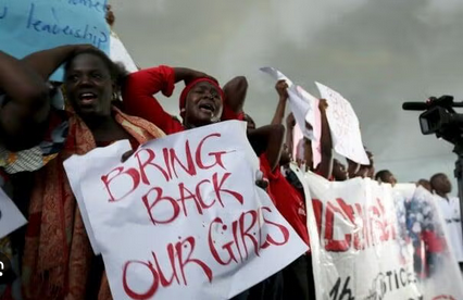 Protesters holding signs demanding the return of girls, highlighting activism and social justice efforts.