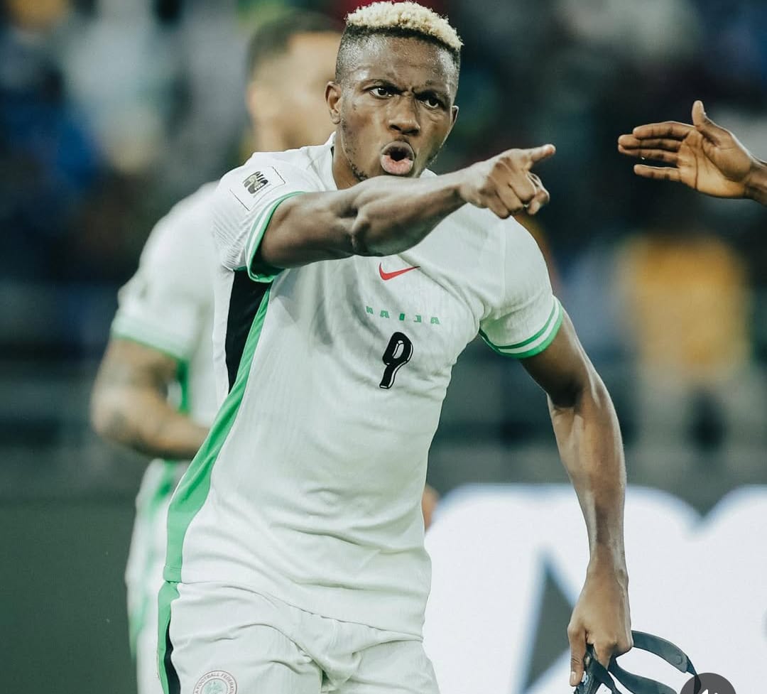 Vibrant football player in Nigeria national team jersey passionately celebrating during a match, pointing and showing determination on the field.