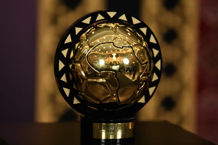 Shiny golden football trophy with black triangular accents, displayed on a stand, symbolising excellence in football awards.