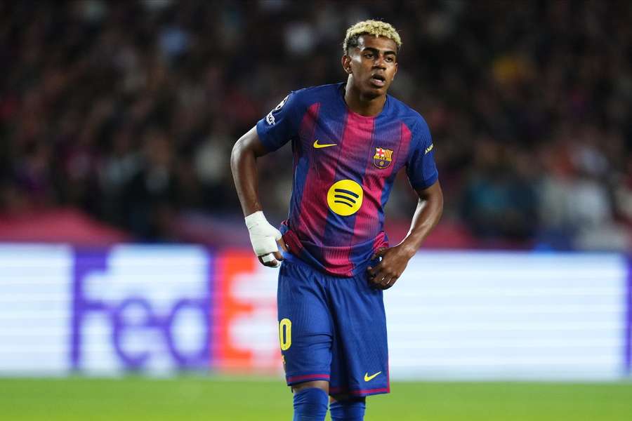 Striker in FC Barcelona football kit during match, sporting sponsor logo, stadium background.