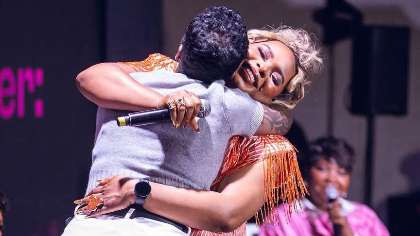Warm embrace between two performers during a live concert or event, highlighting celebration, connection, and entertainment at Freelanews-focused event.