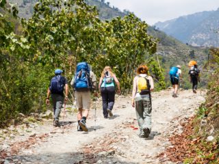 A group of people trekking on dirt road in Nepal