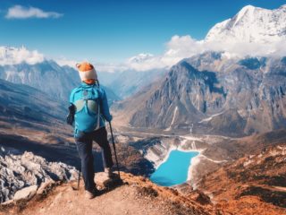 Woman with backpack on the mountain peak in autumn
