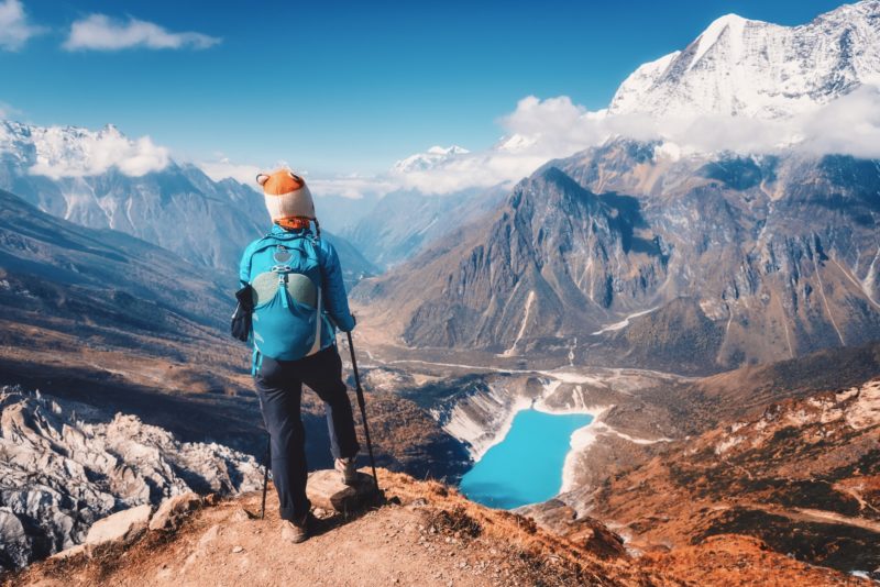 Woman with backpack on the mountain peak in autumn
