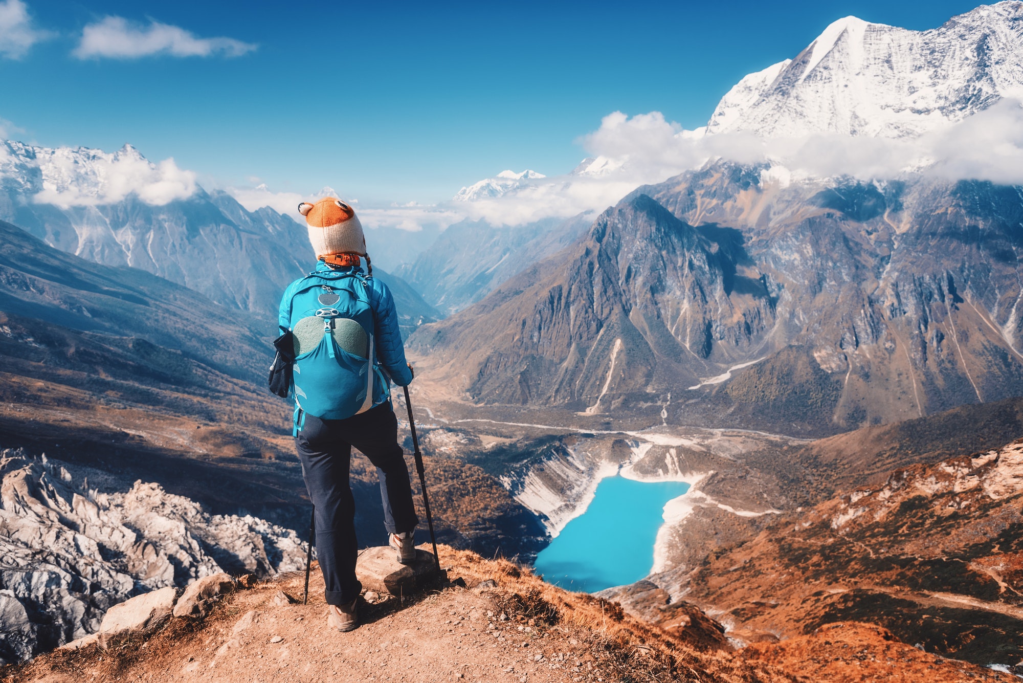 Woman with backpack on the mountain peak in autumn