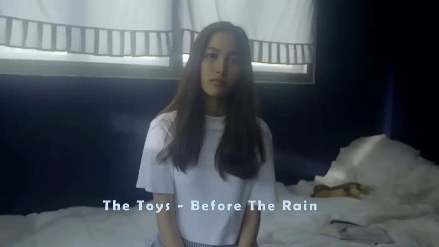 Freen Sarocha in the “Before the Rain” music video, captured in a dramatic cinematic scene.