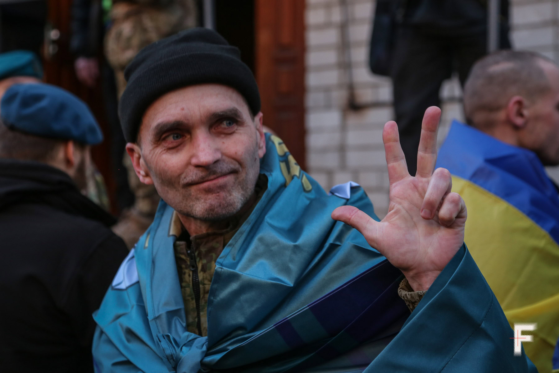 Український військовий після обміну з полону з прапором морської піхоти на плечах, обмін полону 197 захисників