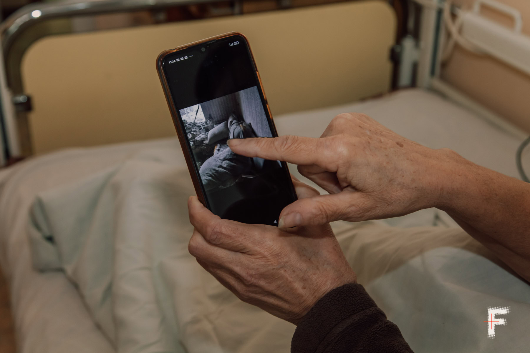 Петровська Галина Василівна показує фотографії свого будинку, який зруйновано внаслідок артилерійського обстрілу міста.
