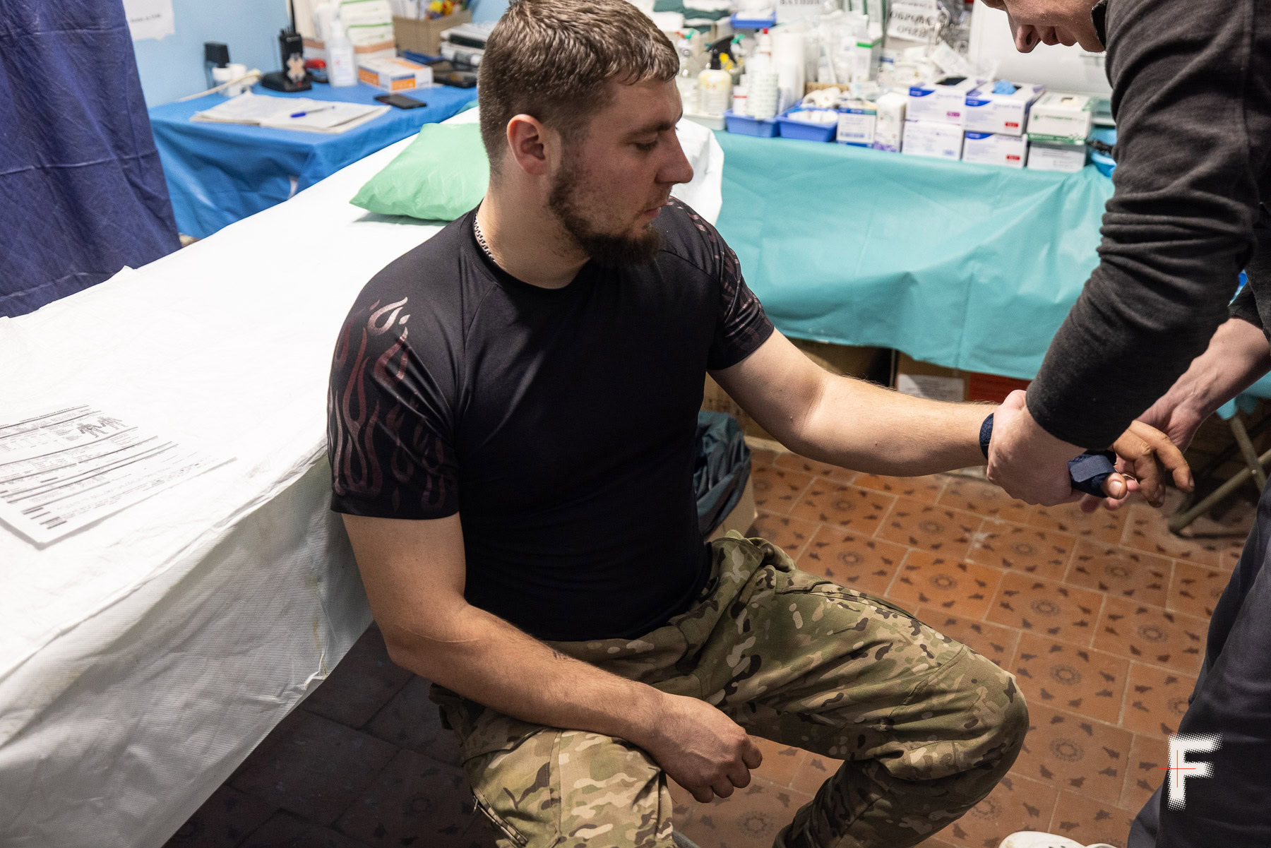 Лікар оглядає водія евакуаційного екіпажу 28-ї бригади на позивний «Скрудж»