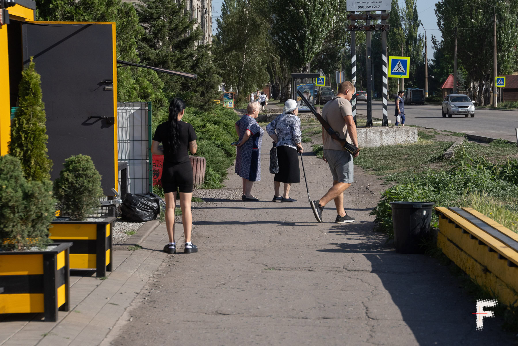 Архівне фото від 10 липня 2025 року: Владислав – власник вуличної точки з шаурмою та кавою – тримає мисливську рушницю для потенційного відбиття атаки російських fpv-дронів. Він чергує та охороняє робітників свого мобільного фастфуду – вагончика на колесах. Добропілля, 19 липня 2025 року. Фото: Андрій Дубчак / Frontliner