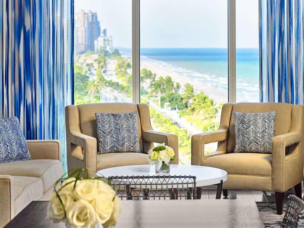 Hotel guestroom seating area with a beach view.