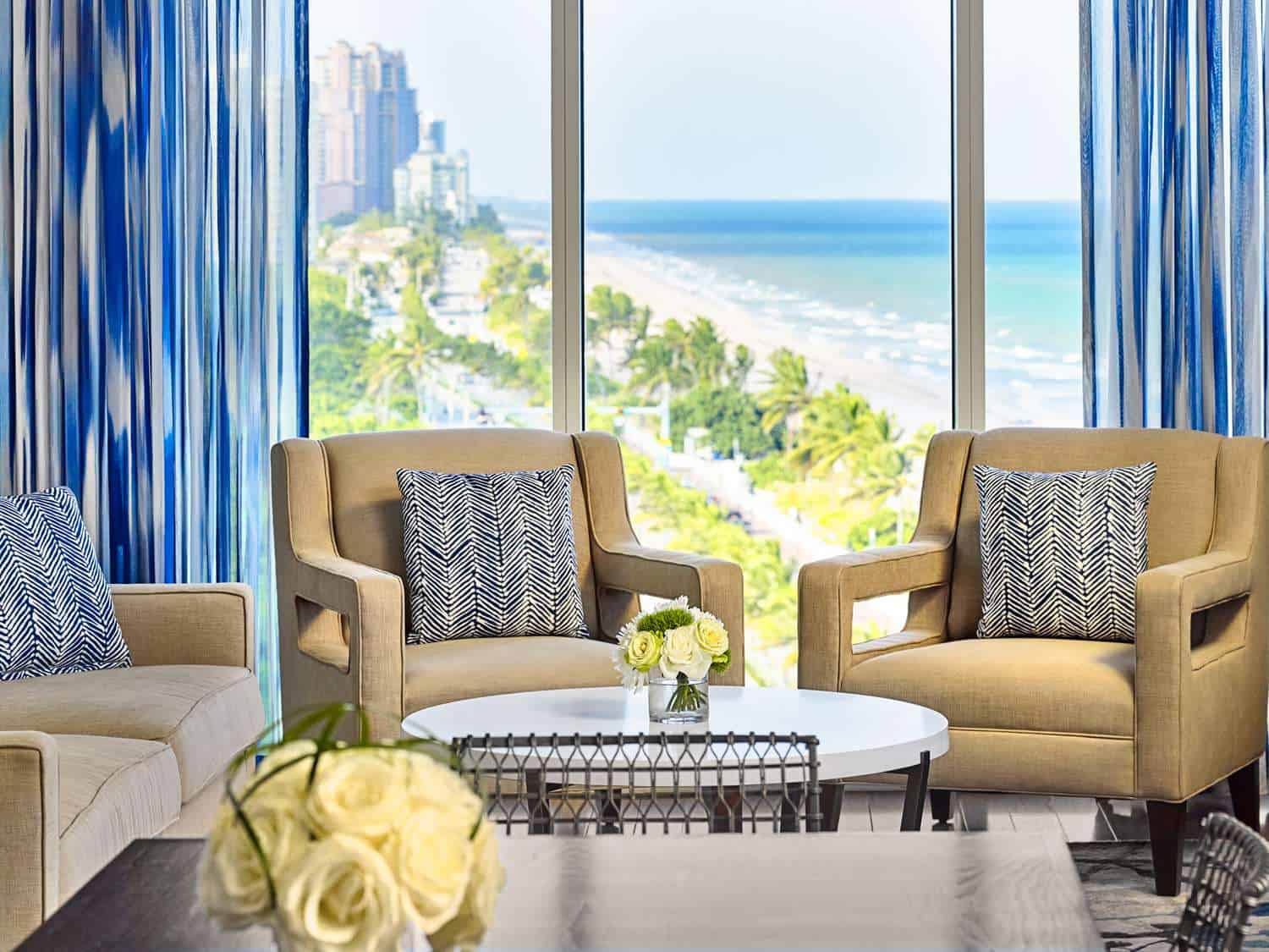 Hotel guestroom seating area with a beach view.