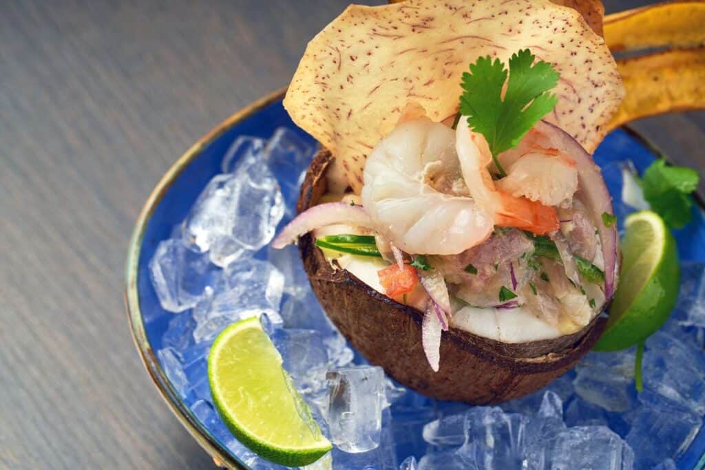 Shrimp ceviche served in coconut shell with lime.