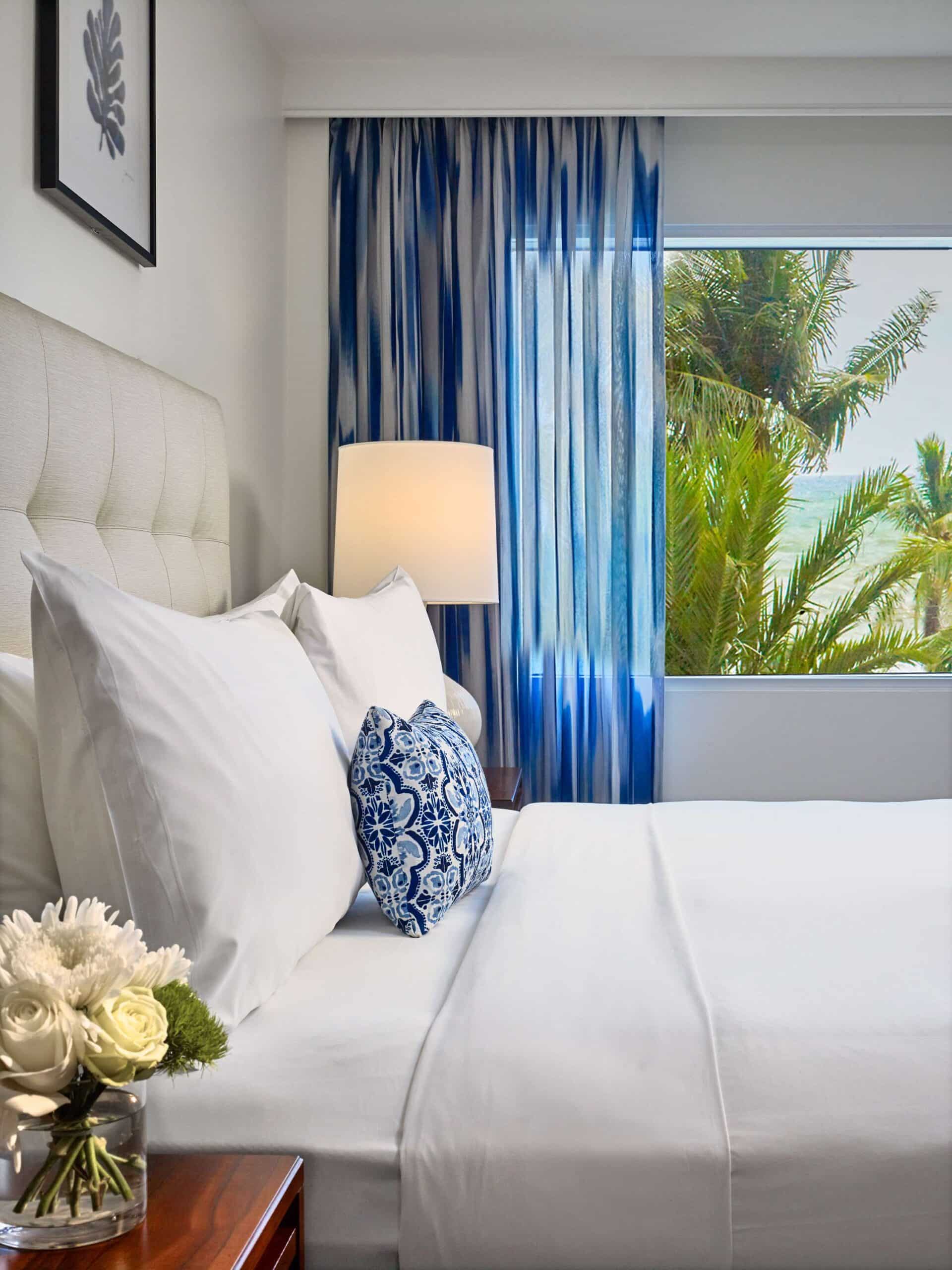 Hotel guestroom bed and a beach view.