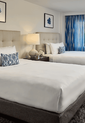 A cozy hotel room showcasing two beds and a TV, designed for relaxation and convenience.