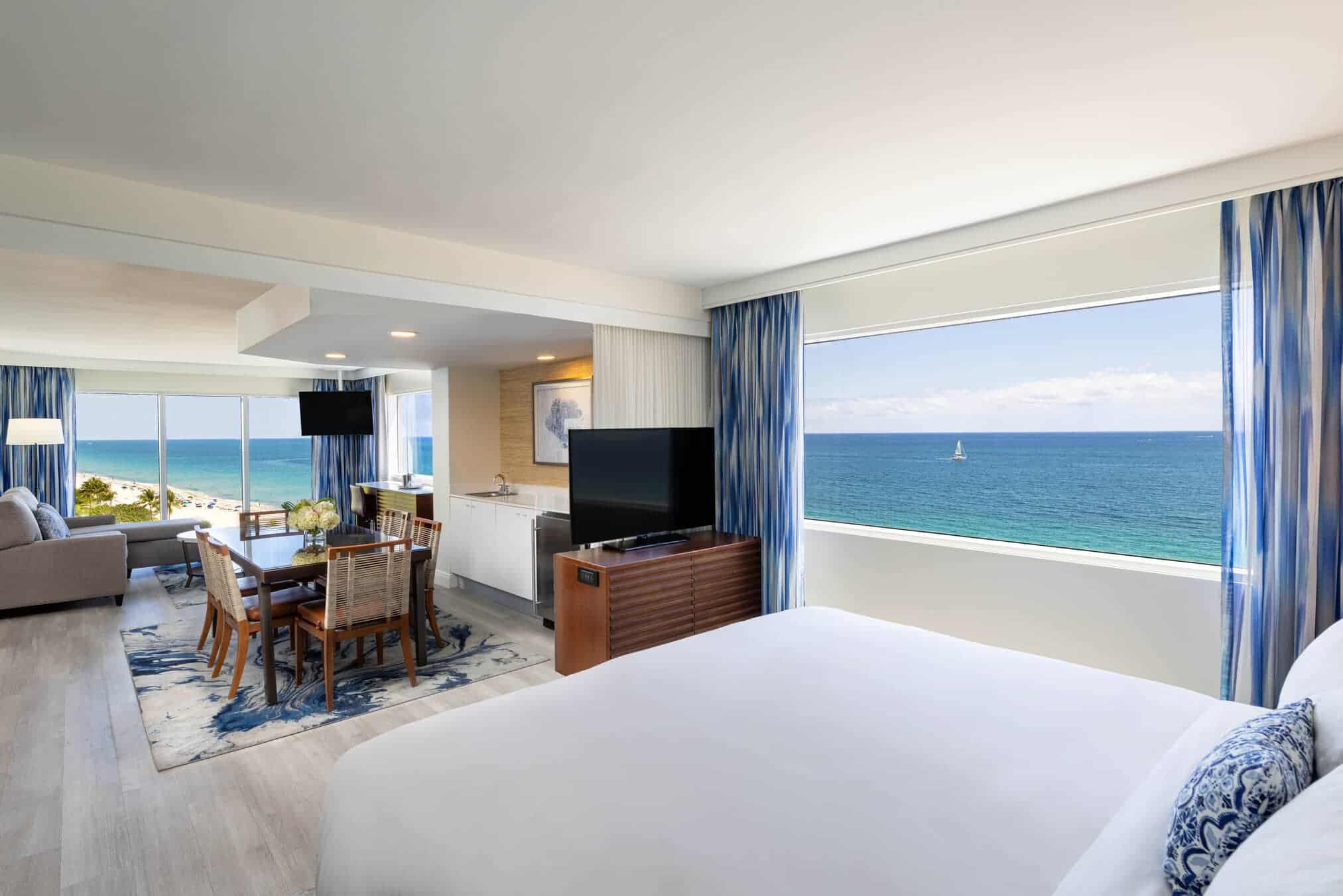 A spacious bedroom featuring large windows with a stunning view of the ocean.
