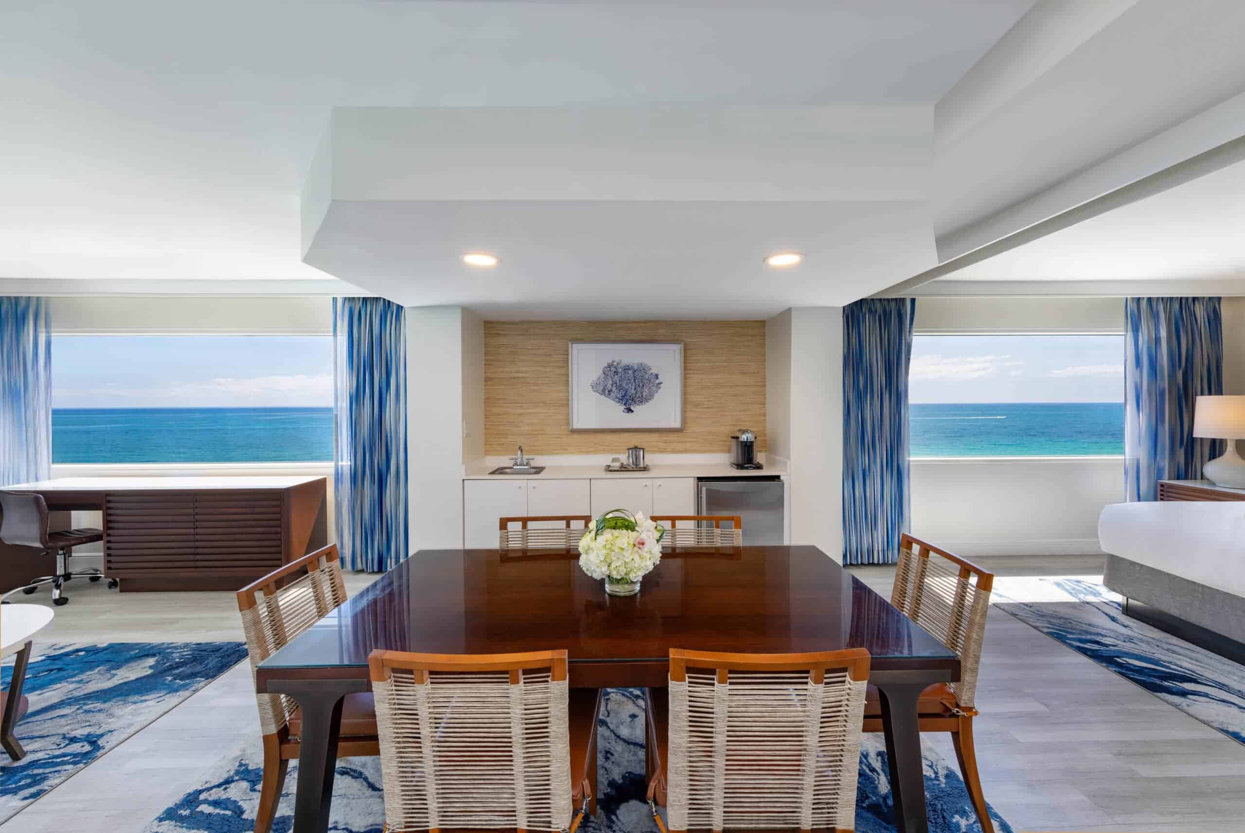 A spacious room featuring a large dining table surrounded by several chairs.