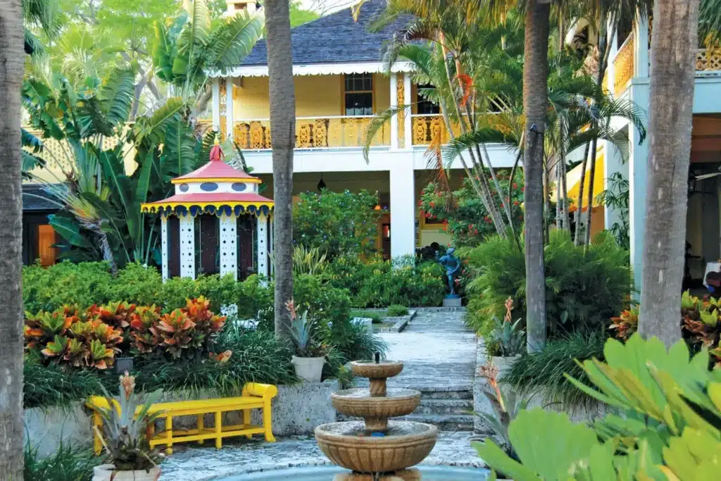 Colorful garden with fountain and gazebo in lush setting.