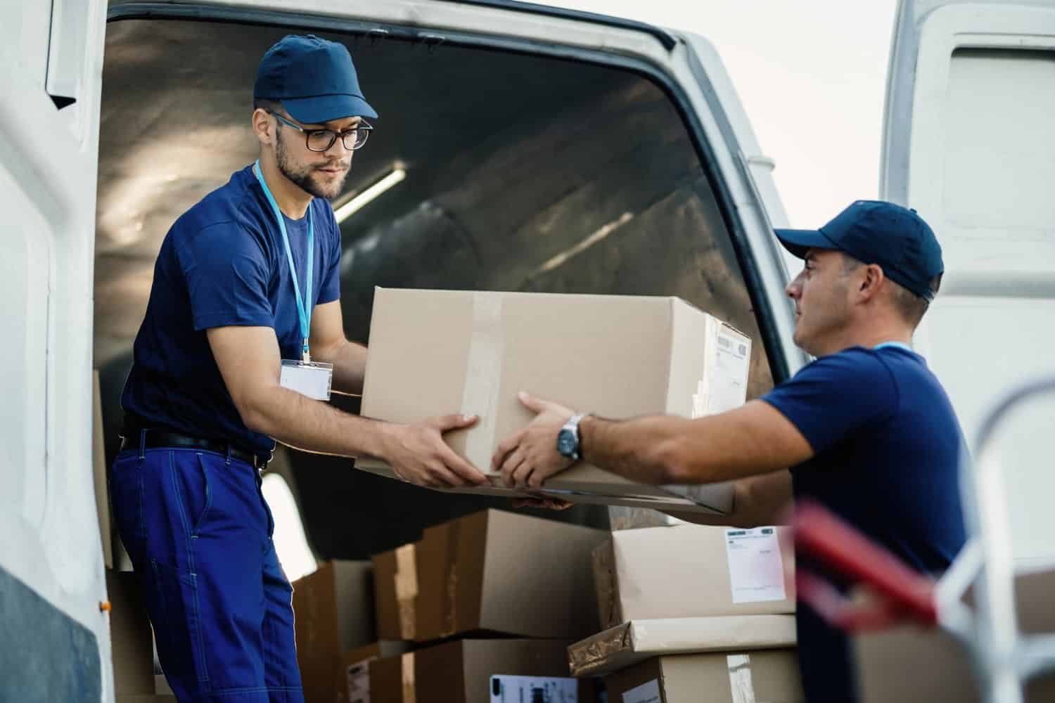 Two movers loading boxes into a moving van in Vancouver.