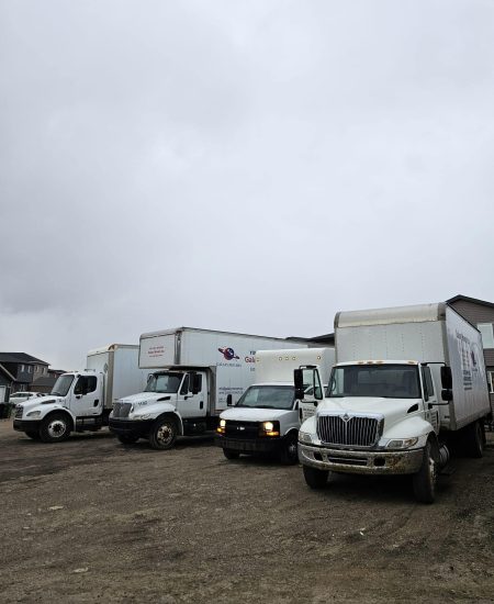 Moving trucks parked outdoors on a cloudy day at Galaxy Movers Calgary.