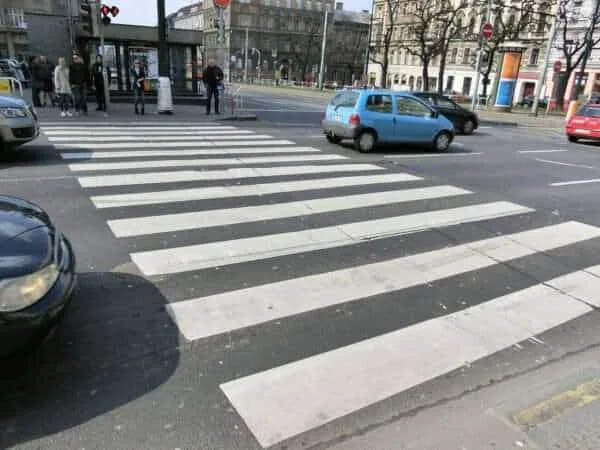 Pedestrian crosswalk at a busy Boston intersection with approaching vehicles