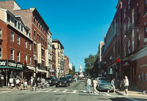 Pedestrian crosswalk at a busy Boston intersection with approaching vehicles