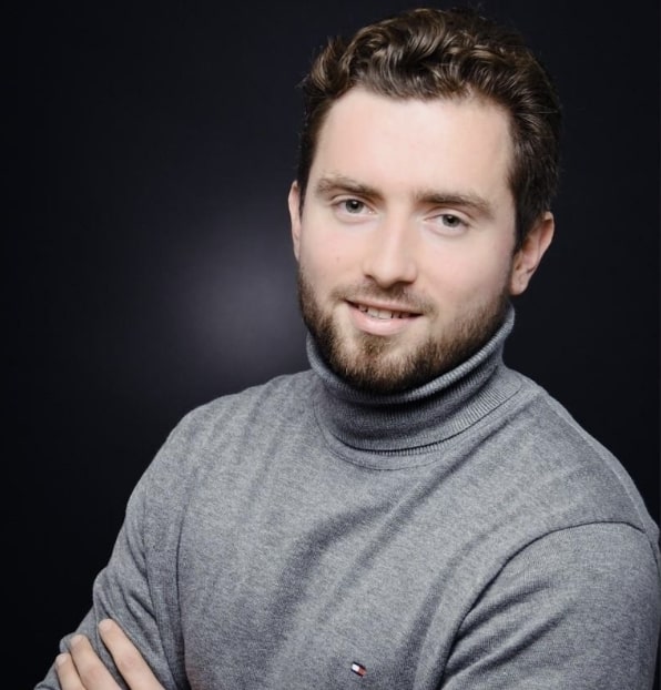 Unser Kunde Mark A. steht mit verschlossenen Armen da und lacht in die Kamera.