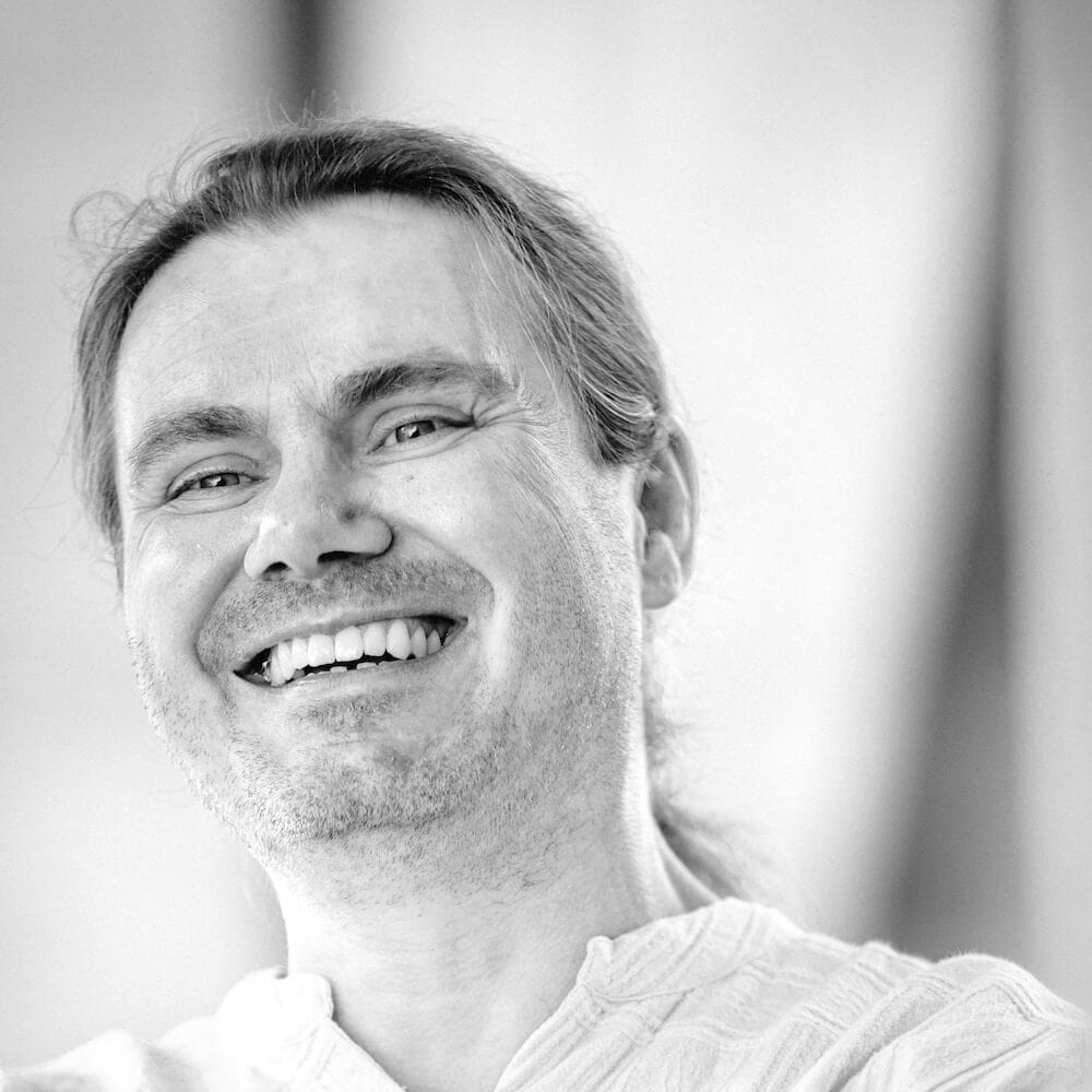 Marc Haunschild in Schwarz-Weiß. Er lacht in die Kamera.