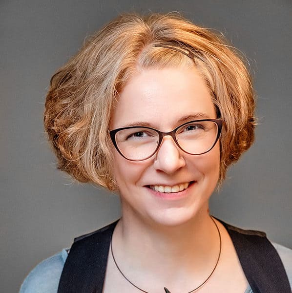 Nicola Pridik mit Brille. Sie lacht in die Kamera.