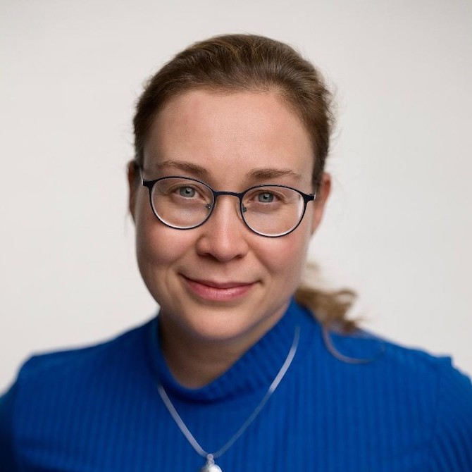 Katrin Zinke mit brauen Haaren, einer Brille und einem blauen Pullover.