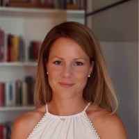 Maike Seidl lächelt in die Kamera. Sie hat lange blonde Haare und ein weißes T-Shirt an.