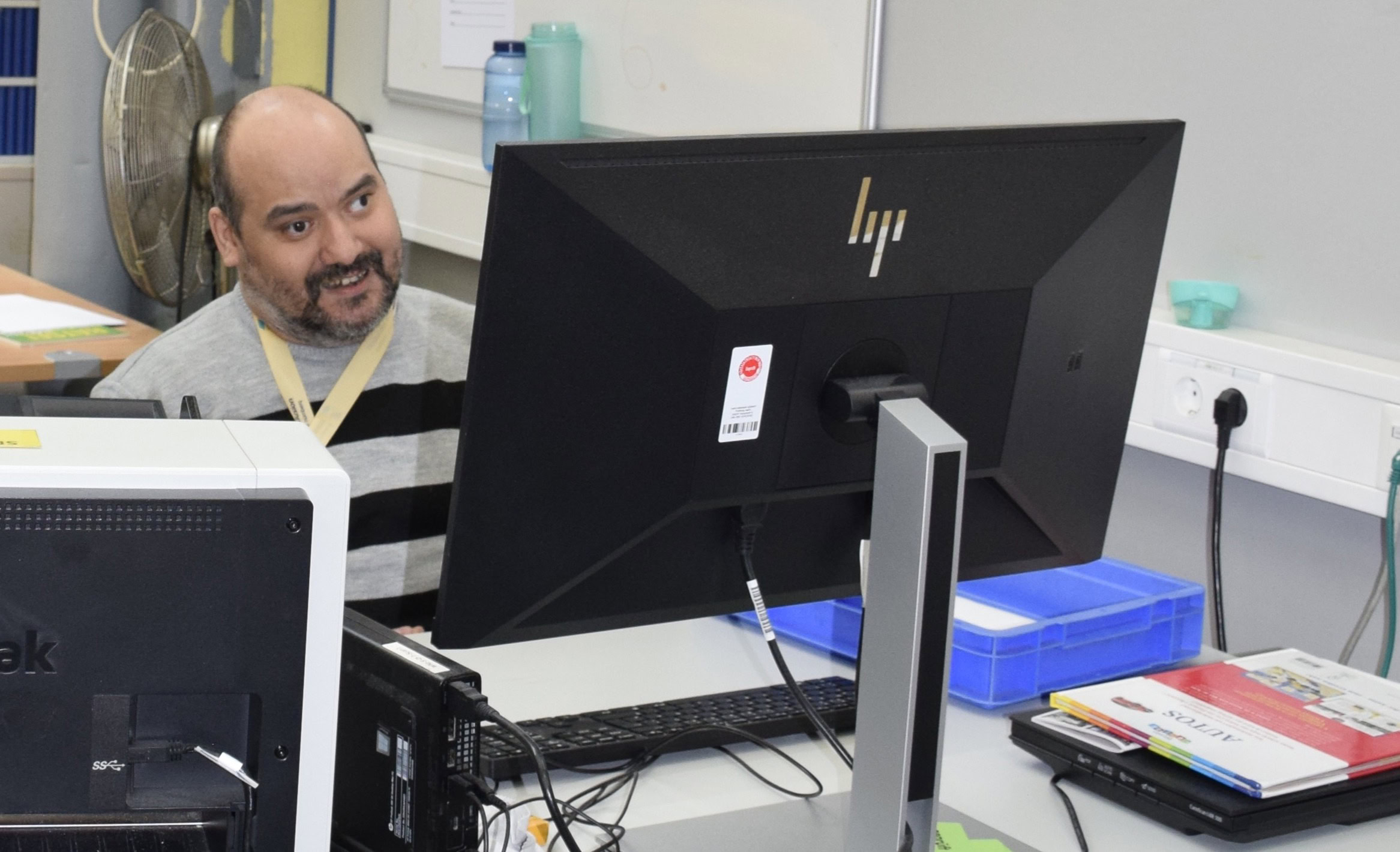 Eine Person mit Lernbehinderung sitzt vor einem Laptop und macht einen Test.