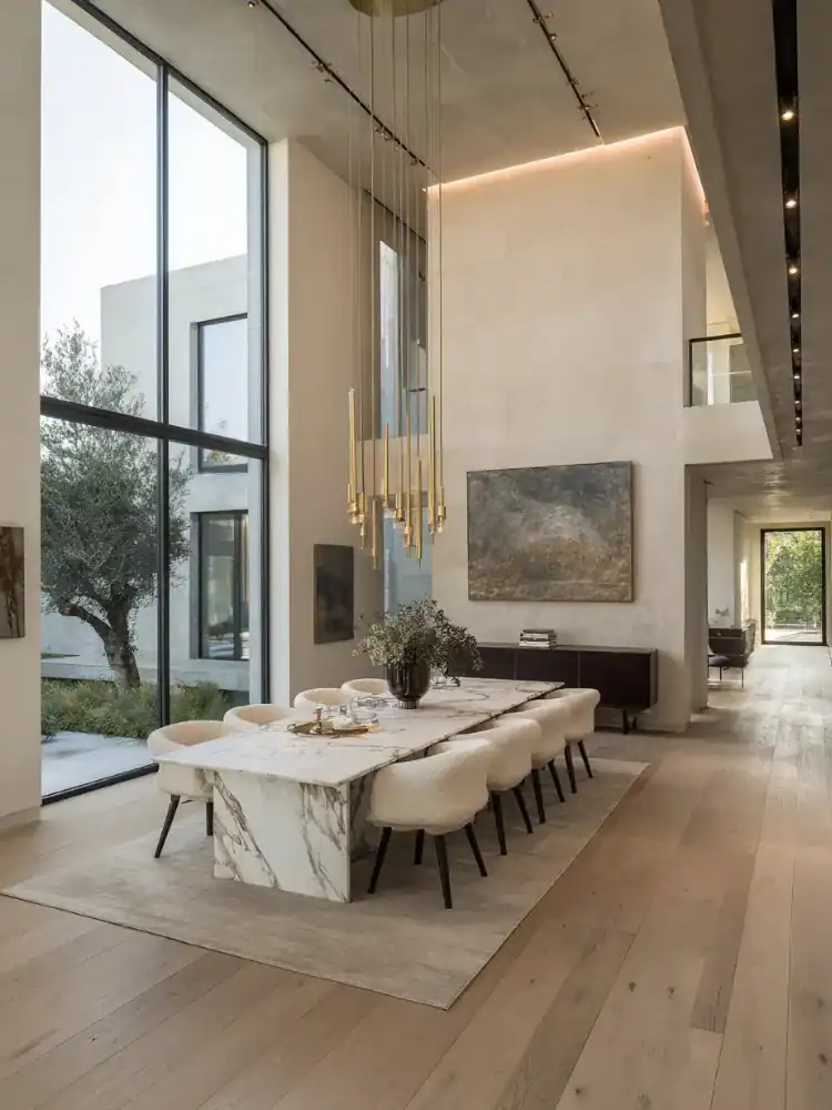 Elegant modern dining room with marble table and stylish chairs, featuring minimalist design and natural light.