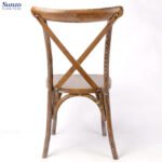Traditional wooden dining chair with cross-back design for rustic or vintage interior decor.