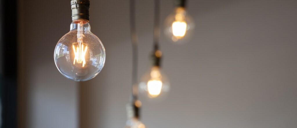 Edison-style filament light bulbs hanging with warm glow, modern lighting decor.