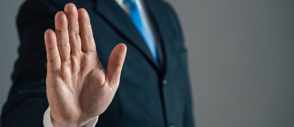 Avoiding confrontation with a raised hand gesture in a professional setting.